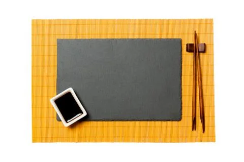 Empty rectangular black slate plate with chopsticks for sushi and soy sauce o Foto stock
