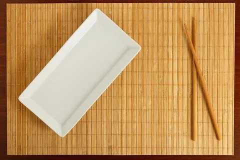 Empty rectangular dish with chopsticks on bamboo surface Stock Photos