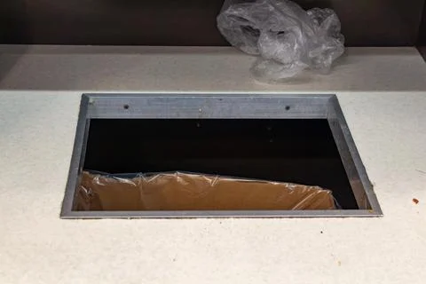 Empty rectangular hole in a white counter top for installation of a kitchen 스톡 사진