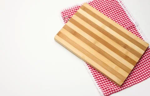 Empty rectangular wooden kitchen cutting board and red towel in a white cage  Stock Photos