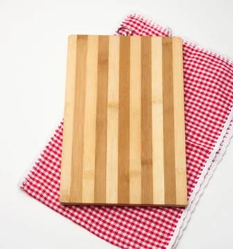 Empty rectangular wooden kitchen cutting board and red towel in a white ca... Foto stock