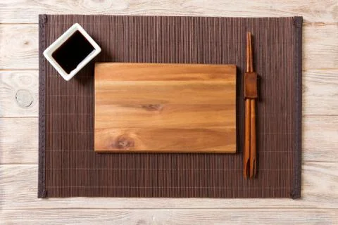 Empty rectangular wooden plate with chopsticks for sushi and soy sauce on woo Foto stock