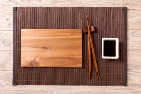 Empty rectangular wooden plate with chopsticks for sushi and soy sauce on woo Stockfoto's