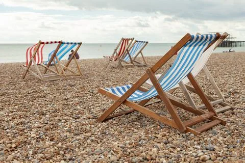 Empty red and blue striped deck chairs in Brigthon, UK. Stock Photos