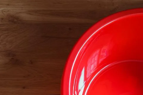Empty red basin on a wooden background. Stock Photos
