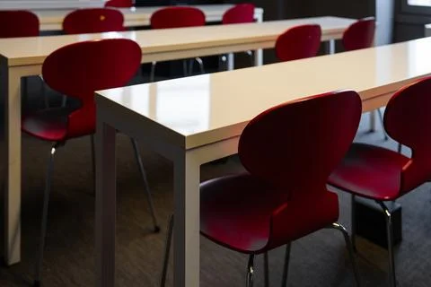 Empty red chairs and tables in modern classroom Stock Photos