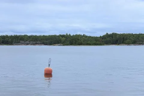 Empty red mooring buoy floating on water in Baltic sea marina. No boats visib Stock Photos
