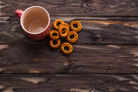 Empty red mug and bagels on a dark wooden table Stock Photos