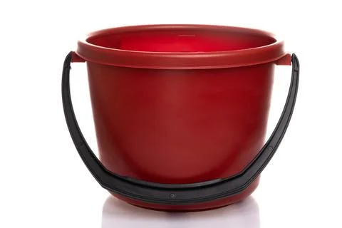 Empty red plastic bucket with black handle on white background Stock Photos