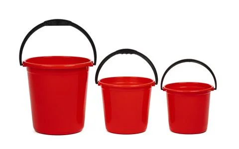 Empty red plastic household bucket on a white background Stock Photos