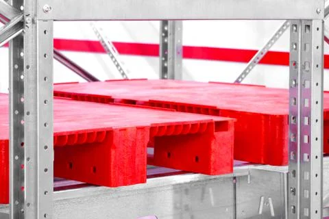 Empty red plastic pallets on racks in an automated warehouse complex Stock-Fotos
