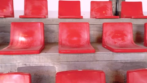 Empty red plastic seats arranged in rows on a concrete stand Stock Footage 320184390