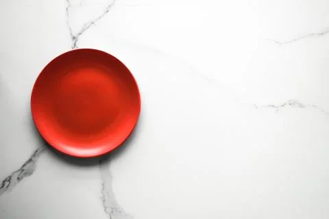 Empty red plate on marble - recipe and restaurant mockup flatlay concept Stock Photos