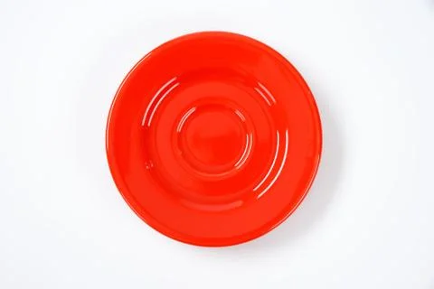 Empty red saucer on off-white background Foto stock