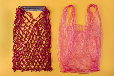 Empty red string reusable eco bag and pink plastic bag Stock Photos