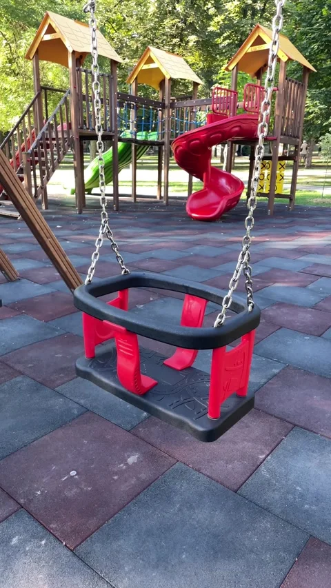 Empty red swing in a sunny playground, outdoor play Stock Footage 342986554