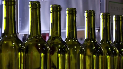 Empty red wine bottles on a coveyer belt ready for filling in South Australia Stock Footage 131307044