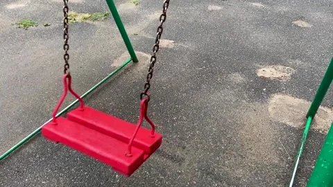 Empty red wooden swing swinging in the rain Stock Footage 162018286
