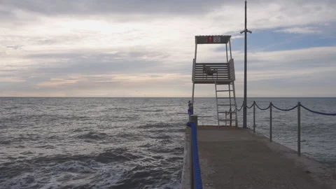 An empty rescue tower stands on a breakwater on the shore. Stock Footage 193860515