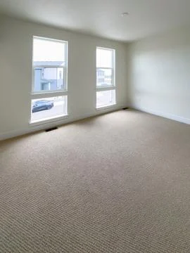 Empty residential room with windows and carpet Stock Photos