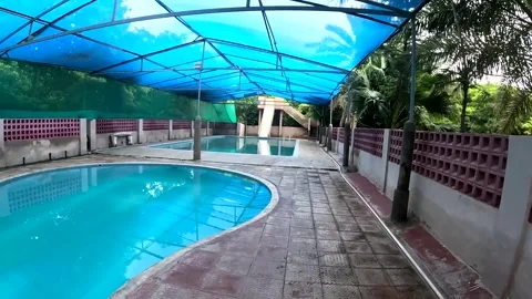 Empty Resort Swimming Pool with Water Slide Under Blue Shade Stock Footage 341033805