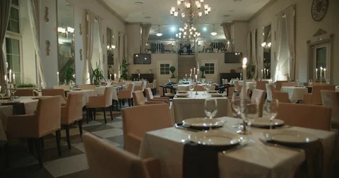 An empty restaurant hall, a table for two served candle light, ready to receive Stock Footage 85044627
