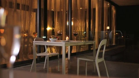 An empty restaurant is ready for a romantic date. On the table are glasses of Stock Footage 78281021