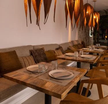 Empty restaurant of a rustic hotel with tables prepared for dinner in a bad s Stock Photos