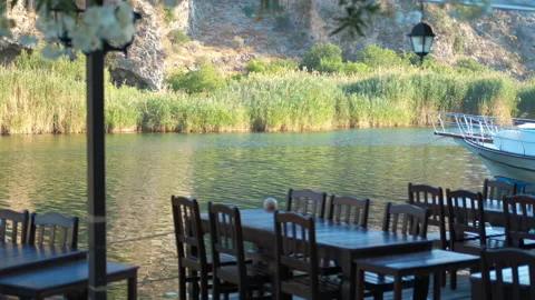 Empty restaurant tables by the river await guests Stock Footage 311009544