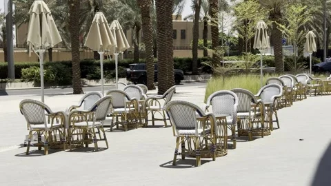 Empty restaurant terrace with wicker chairs and umbrellas on a sunny day. Vídeo Stock 337406913