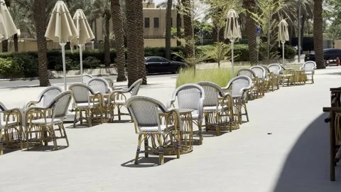 Empty restaurant terrace with wicker chairs and umbrellas on a sunny day. Stock Footage 337406914