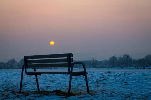 Empty resting bench at sunrise in winter Stock Photos