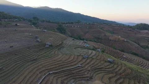 Empty rice plots lie still in valley village setting, Thailand 스톡 동영상 309119048