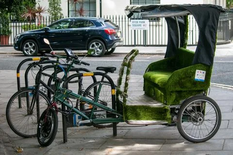Empty rickshaw parked by a bicycle rack in London Stock Photos