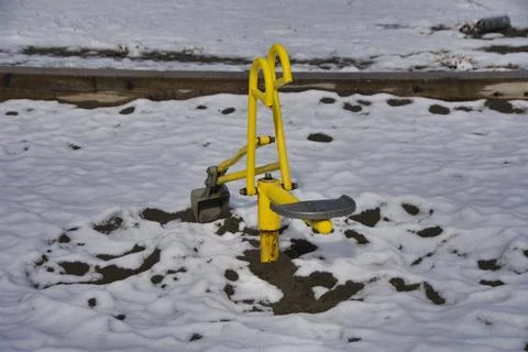 Empty Ride-On Sandbox Digger on children's playground under the snow. Stock Photos