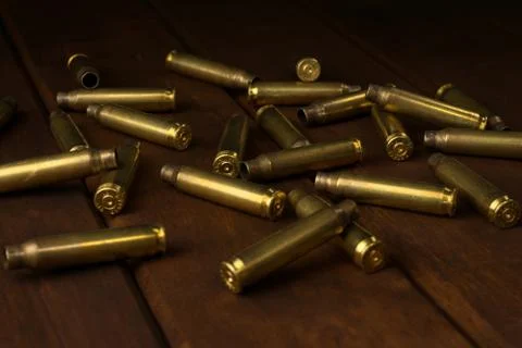 Empty rifle shells on dark wooden board Foto stock