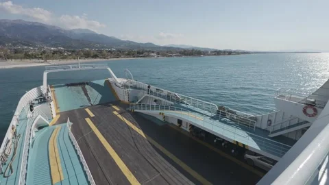 Empty ro-ro ferry deck sailing near coastal city at sunset view Stock Footage 338106430