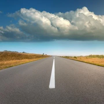 Empty road and idyllic fields at sunny day Stock Photos