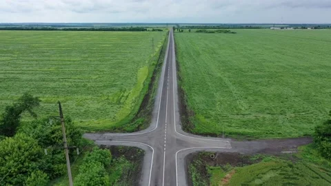 Empty road between green fields aerial view Stock Footage 158695535
