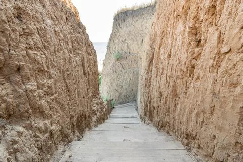 Empty road at the bottom of the abyss in sandy soil. Stock Photos