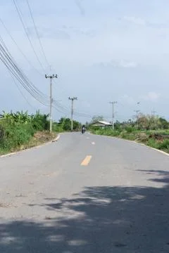 Empty road with electric wire and post and motorbike on the street. Stock Photos