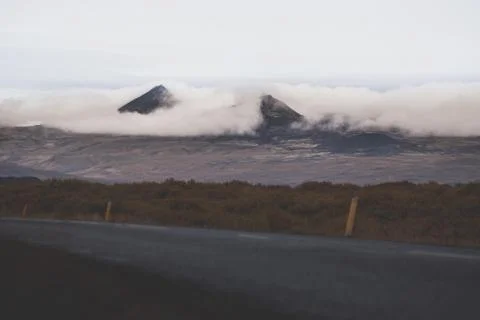 Empty road in front of a mountain range with fog. Lovely landscape and toug.. Stock Photos