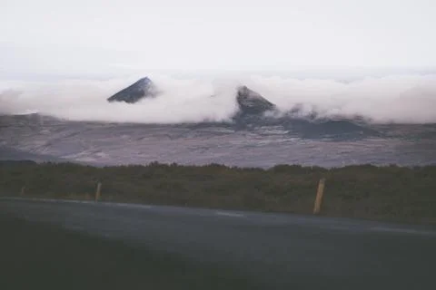 Empty road in front of a mountain range with fog. Lovely landscape and toug.. Stock Photos