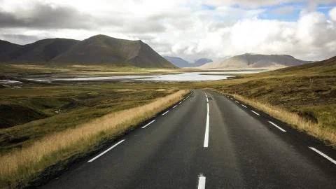 Empty road in front of a mountain range with fog. Lovely landscape and toug.. Stock Photos
