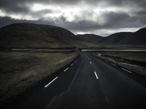 Empty road in front of a mountain range with fog. Lovely landscape and toug.. Stock Photos