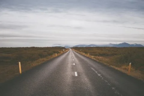 Empty road in front of a mountain range with fog. Lovely landscape and toug.. Stock Photos
