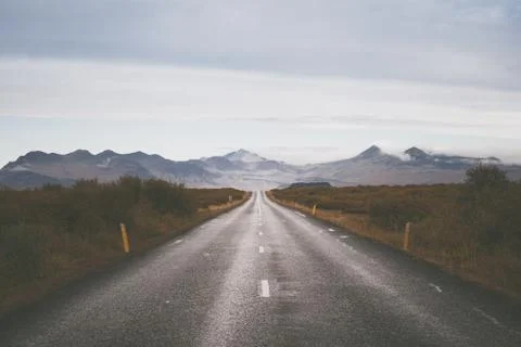 Empty road in front of a mountain range with fog. Lovely landscape and toug.. Stock Photos