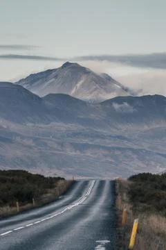 Empty road in front of a mountain range with fog. Lovely landscape and toug.. Stock Photos