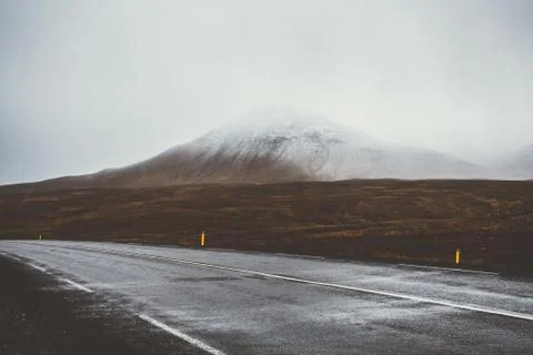 Empty road in front of a mountain range with fog. Lovely landscape and toug.. Stock Photos