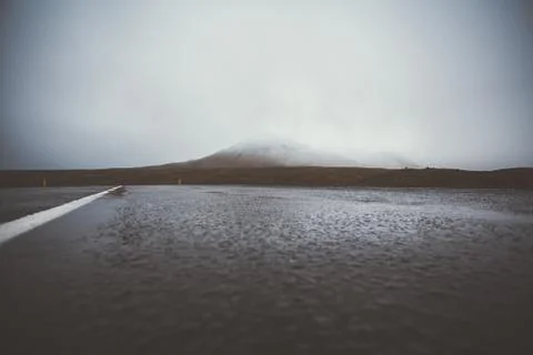 Empty road in front of a mountain range with fog. Lovely landscape and toug.. Stock-Fotos